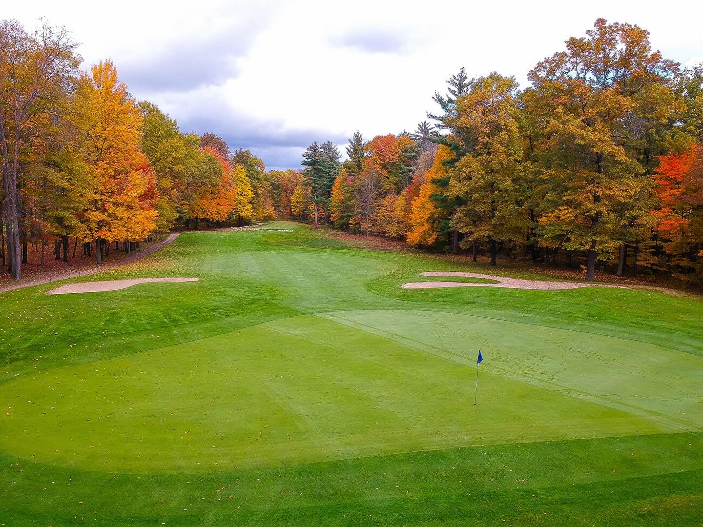 View of golf course fairway lined with trees